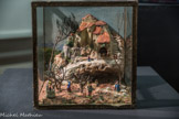 <center>Exposition de crèches en 2017.</center>Gil-Agnès Daumas Datation inconnue Crèche représentant un village avec une grotte.  22,5 x 21,3 x 17,5 cm. <br>